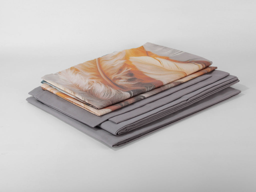 Completo letto matrimoniale INDIA con fantasia di piume nei toni arancio, marrone, grigio e azzurro.