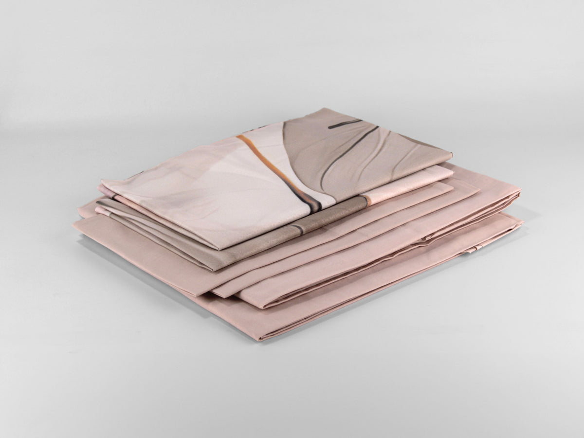 Completo letto matrimoniale RUNA con fantasia astratta nei toni del rosa cipria, beige, tortora e marrone.